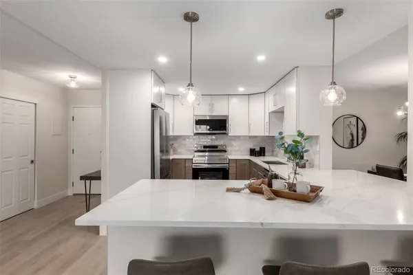 a kitchen with a table chairs refrigerator and microwave