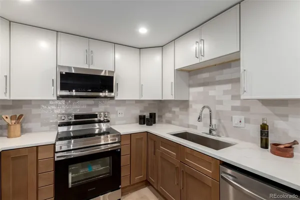 a kitchen with sink a microwave a stove and cabinets
