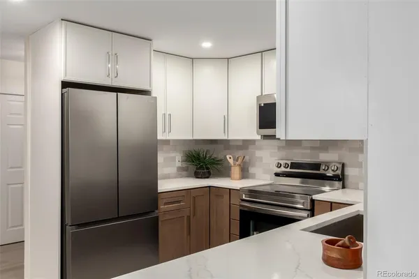a kitchen with a refrigerator and a stove top oven