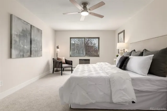 a spacious bedroom with a large bed and a painting on the wall
