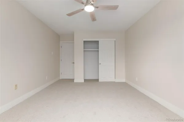 an empty room with a ceiling fan and a window
