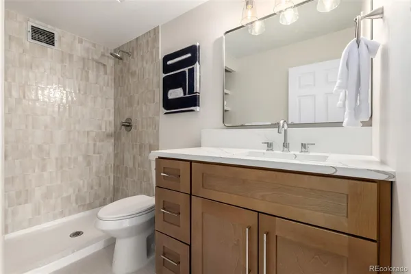 a bathroom with a sink a toilet and shower