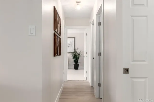 a view of a hallway with wooden floor and windows