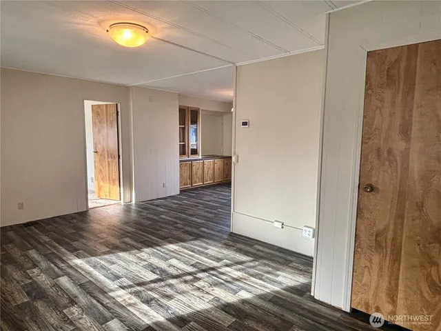 a view of a hallway with wooden floor and a bathroom