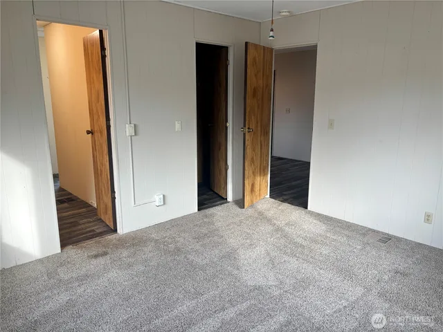 a view of an empty room with closet and a window