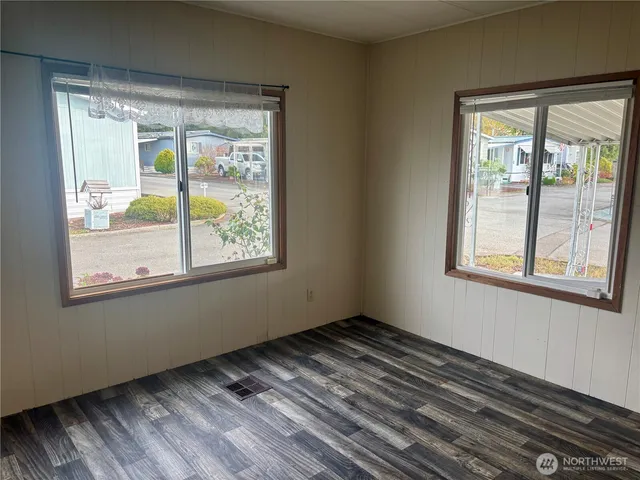 a view of a hallway with wooden floor and a bathroom