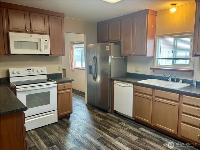 a kitchen with a white stove top oven and refrigerator