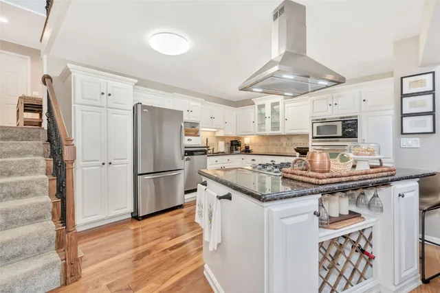 a kitchen with stainless steel appliances a stove a sink and a refrigerator