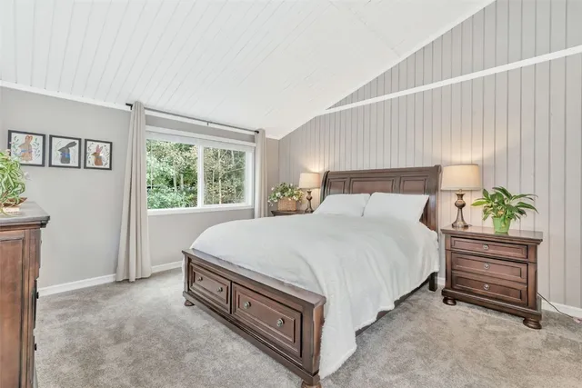 a bedroom with a bed and a large window