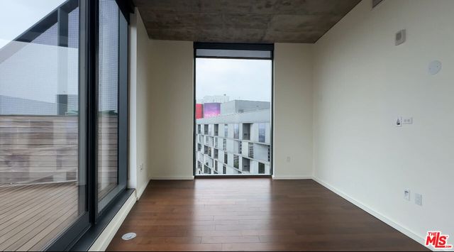 a view of a hallway with wooden floor and windows