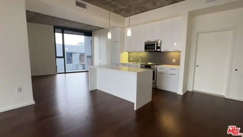 a kitchen with stainless steel appliances granite countertop a refrigerator a stove and a wooden floors