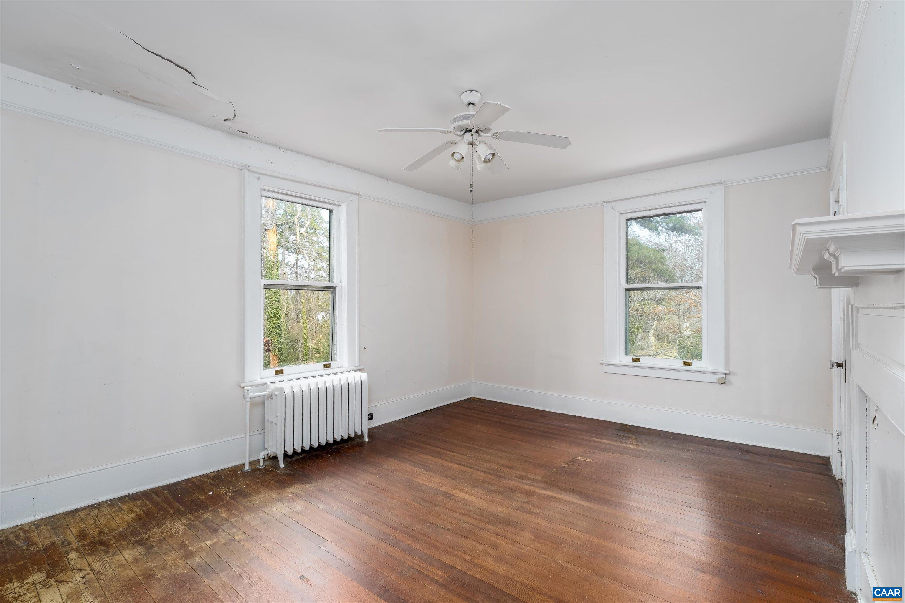 278 James River Road Scottsville, VA 24590 - Photo 37 of 59 an empty room with wooden floor chandelier fan and windows