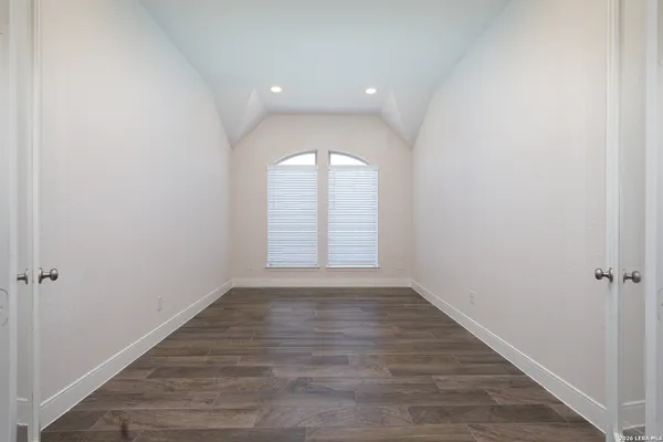 an empty room with wooden floor and window