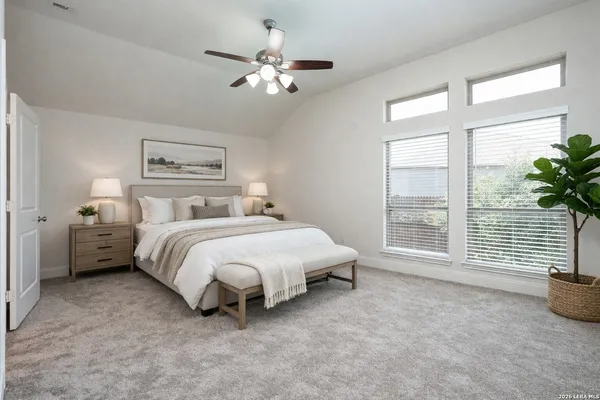 a spacious bedroom with a bed and a chandelier