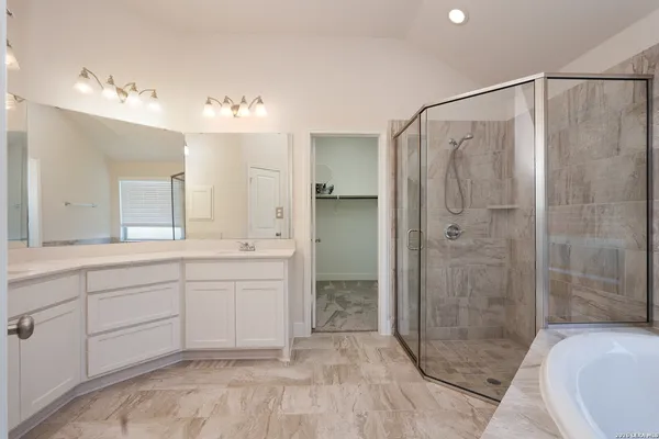 a spacious bathroom with a shower sink vanity and mirror