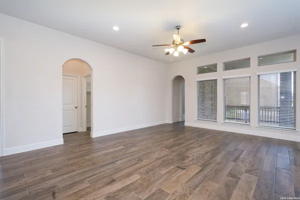 a view of an empty room with a window and wooden floor
