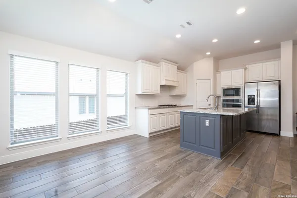 a kitchen with stainless steel appliances kitchen island wooden cabinets and wooden floors