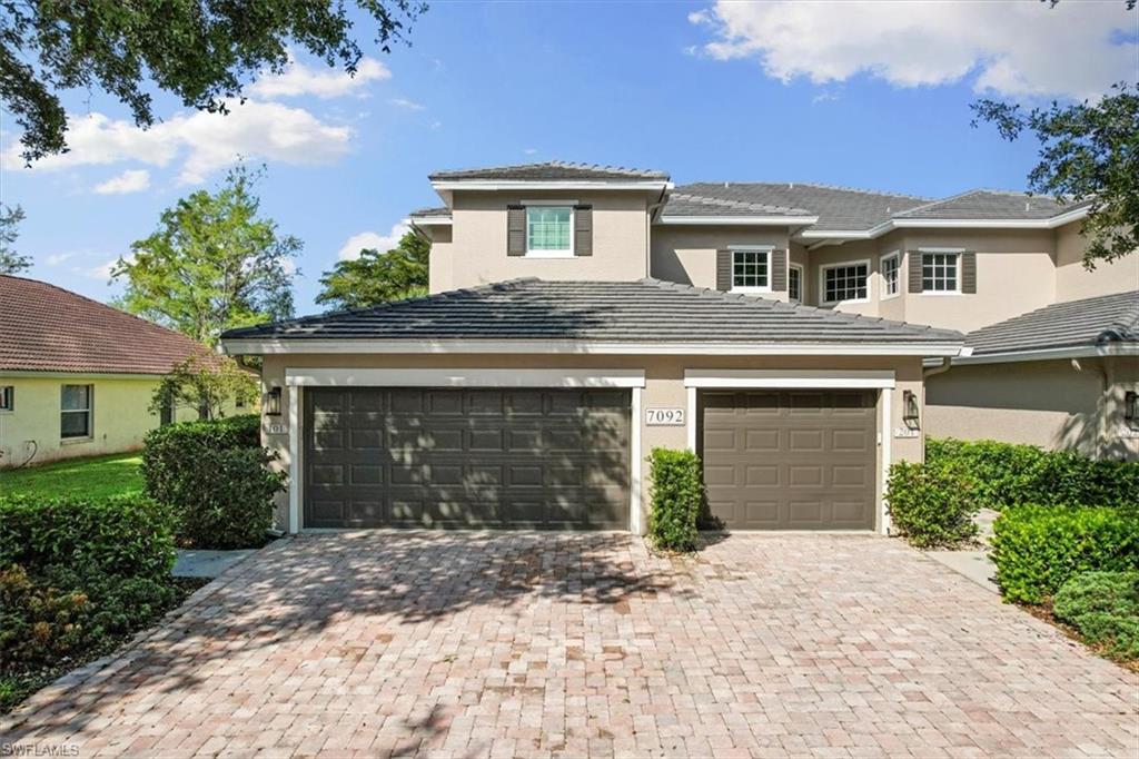 7092 Timberland Circle, Unit 1101 Naples, FL 34109 - Photo 1 of 48 a front view of a house with a yard and garage