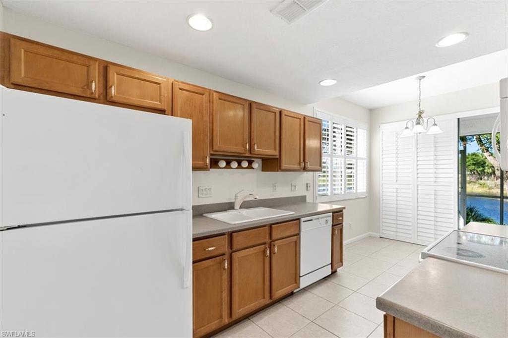 7092 Timberland Circle, Unit 1101 Naples, FL 34109 - Photo 12 of 48 a kitchen with a sink a refrigerator a stove and cabinets