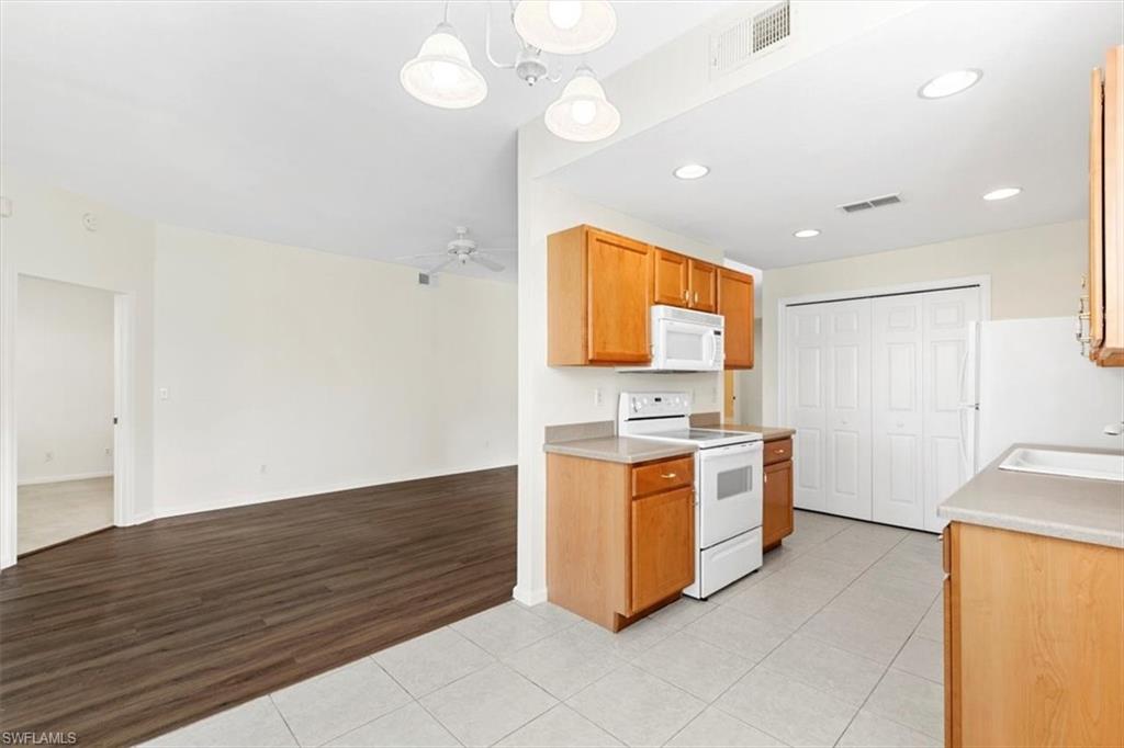 7092 Timberland Circle, Unit 1101 Naples, FL 34109 - Photo 13 of 48 a kitchen with stainless steel appliances granite countertop a sink and a stove