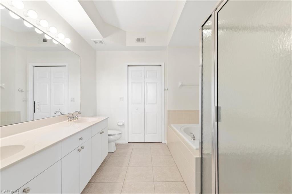7092 Timberland Circle, Unit 1101 Naples, FL 34109 - Photo 19 of 48 a spacious bathroom with a bathtub sink and mirror