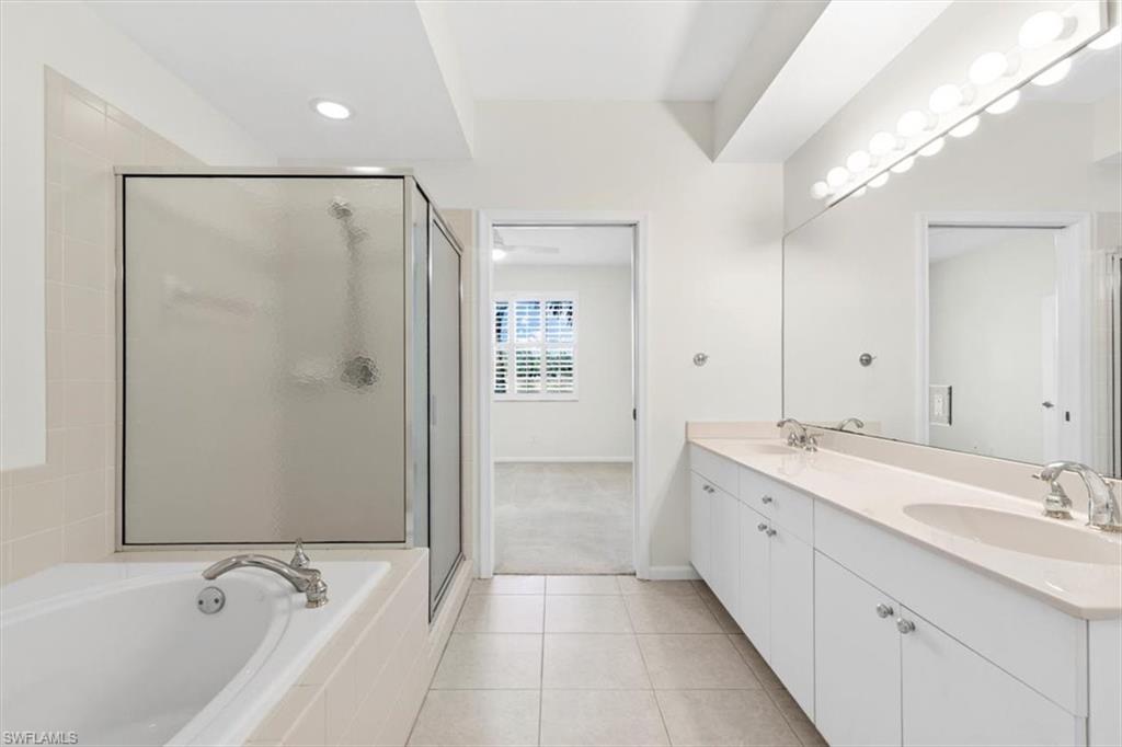 7092 Timberland Circle, Unit 1101 Naples, FL 34109 - Photo 21 of 48 a bathroom with a tub sink and mirror