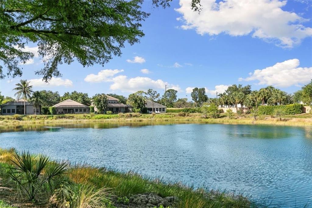 7092 Timberland Circle, Unit 1101 Naples, FL 34109 - Photo 34 of 48 a view of a lake with houses in the back