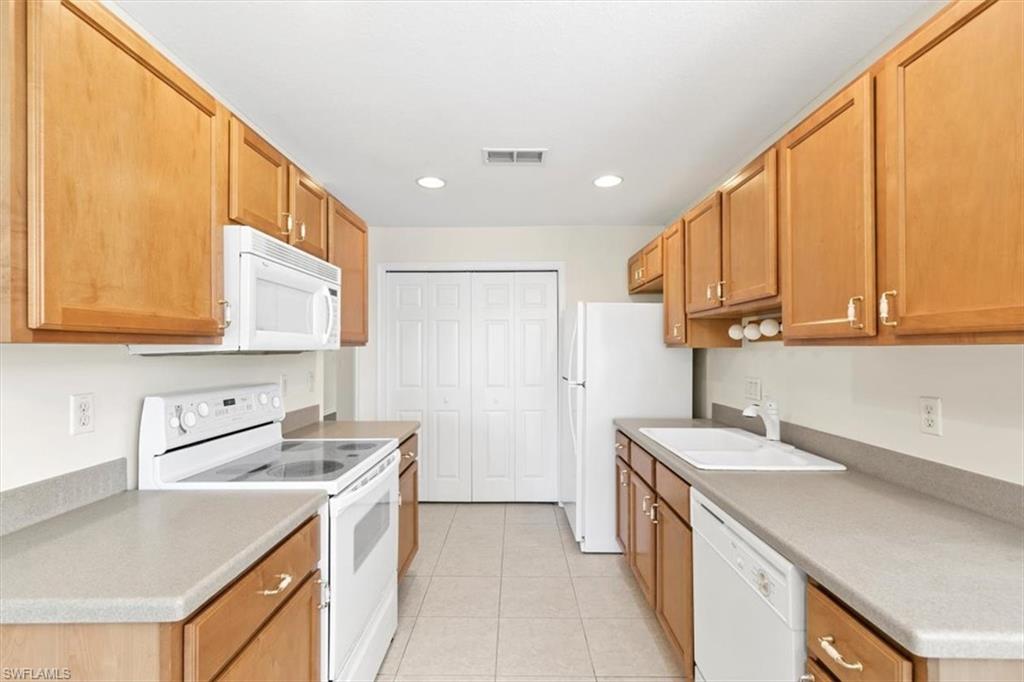 7092 Timberland Circle, Unit 1101 Naples, FL 34109 - Photo 9 of 48 a kitchen with a sink a stove and cabinets
