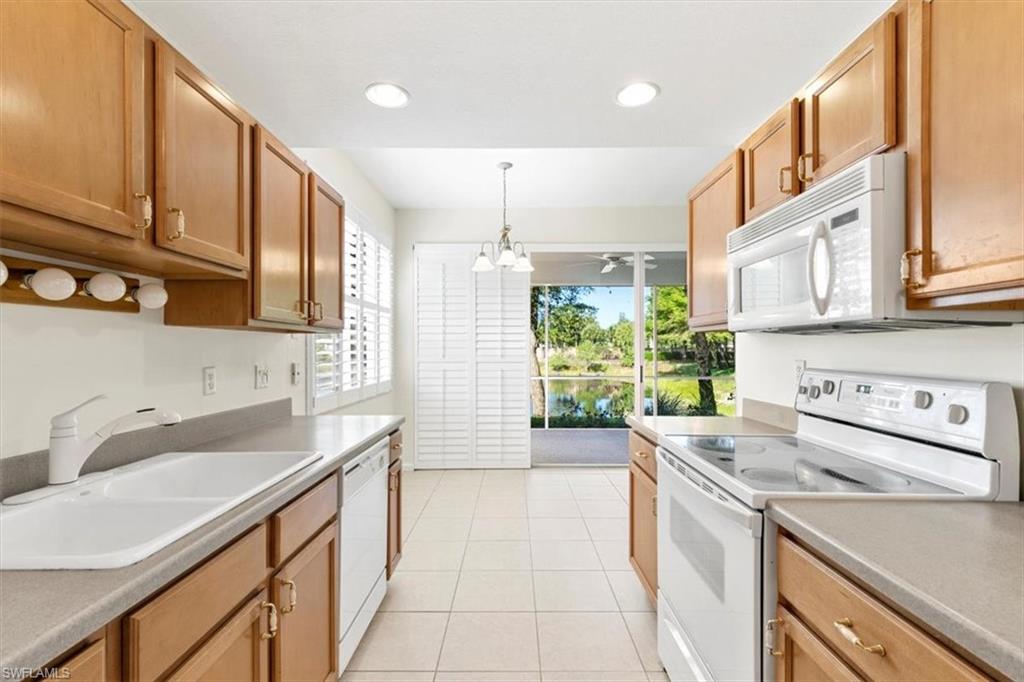 7092 Timberland Circle, Unit 1101 Naples, FL 34109 - Photo 10 of 48 a kitchen with a sink stove and cabinets