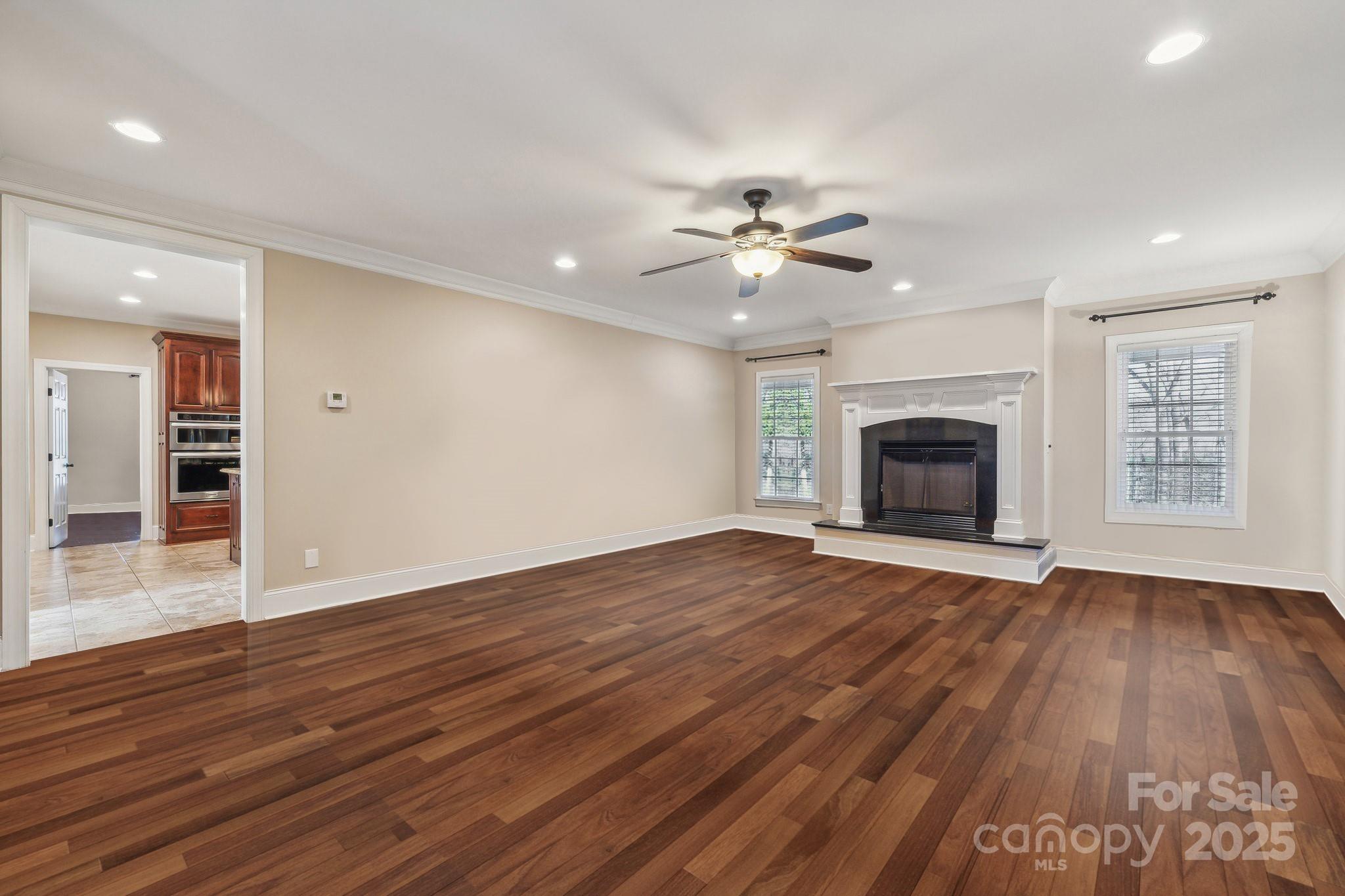 4006 Sincerity Road Monroe, NC 28110 - Photo 4 of 36 an empty room with wooden floor fireplace and a window