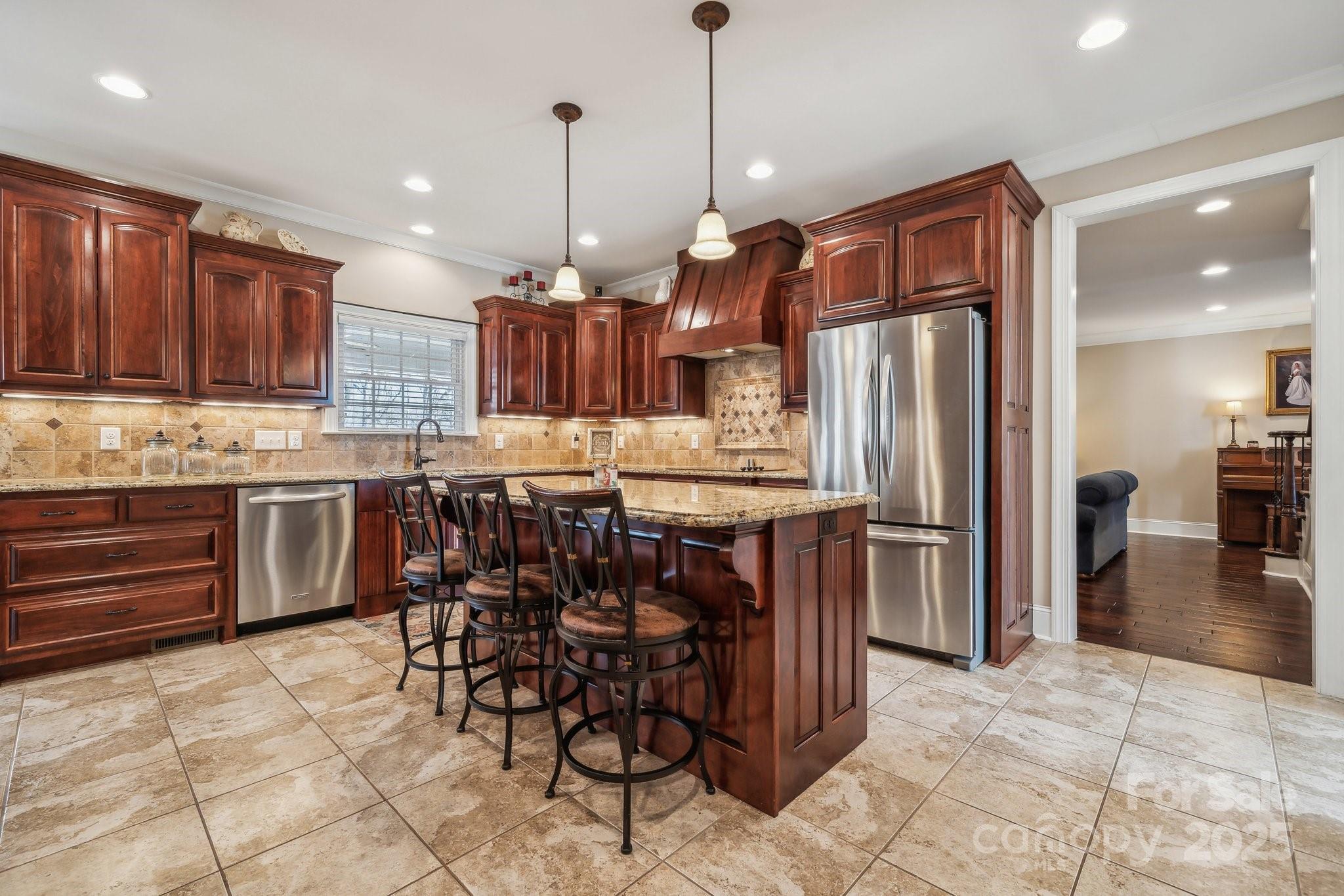 4006 Sincerity Road Monroe, NC 28110 - Photo 10 of 36 a kitchen with stainless steel appliances kitchen island granite countertop a refrigerator and a stove top oven