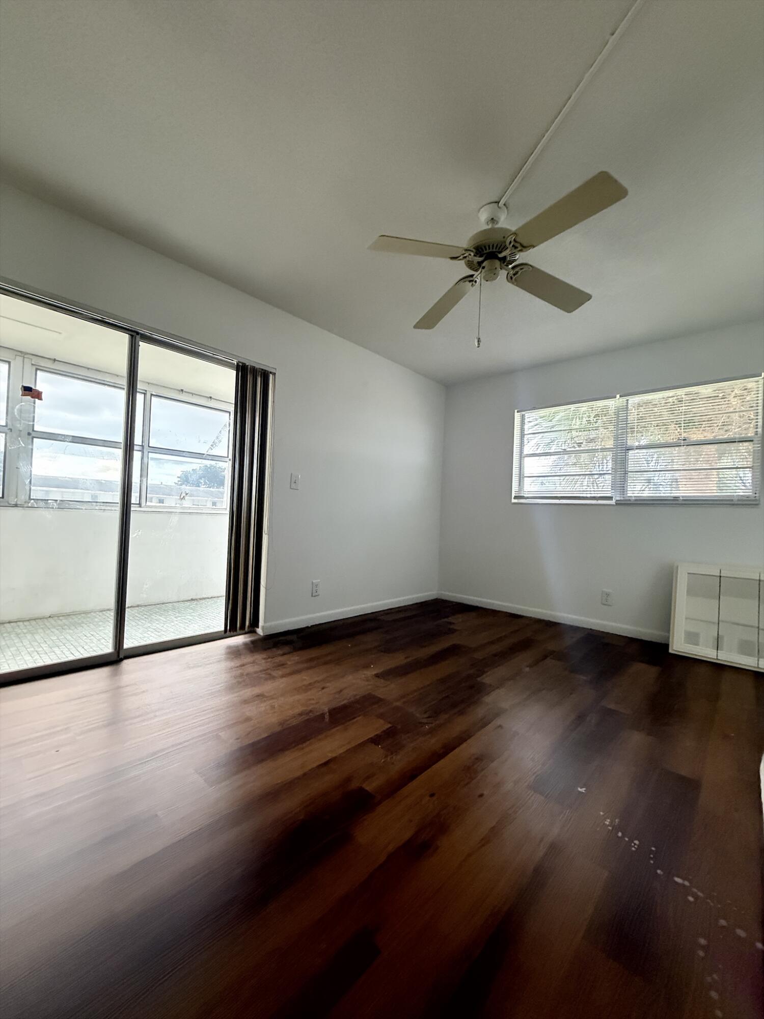 151 Andover F West Palm Beach, FL 33417 - Photo 7 of 10 an empty room with wooden floor and windows