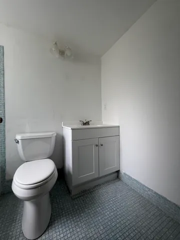 a white toilet sitting next to a bathroom sink