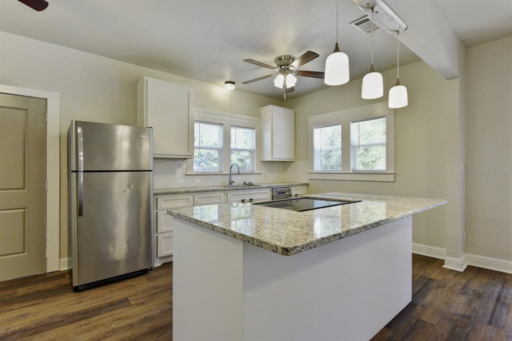 1115 South Rusk Avenue Denison, TX 75020 - Photo 8 of 21 a kitchen with a center island wooden floor and stainless steel appliances