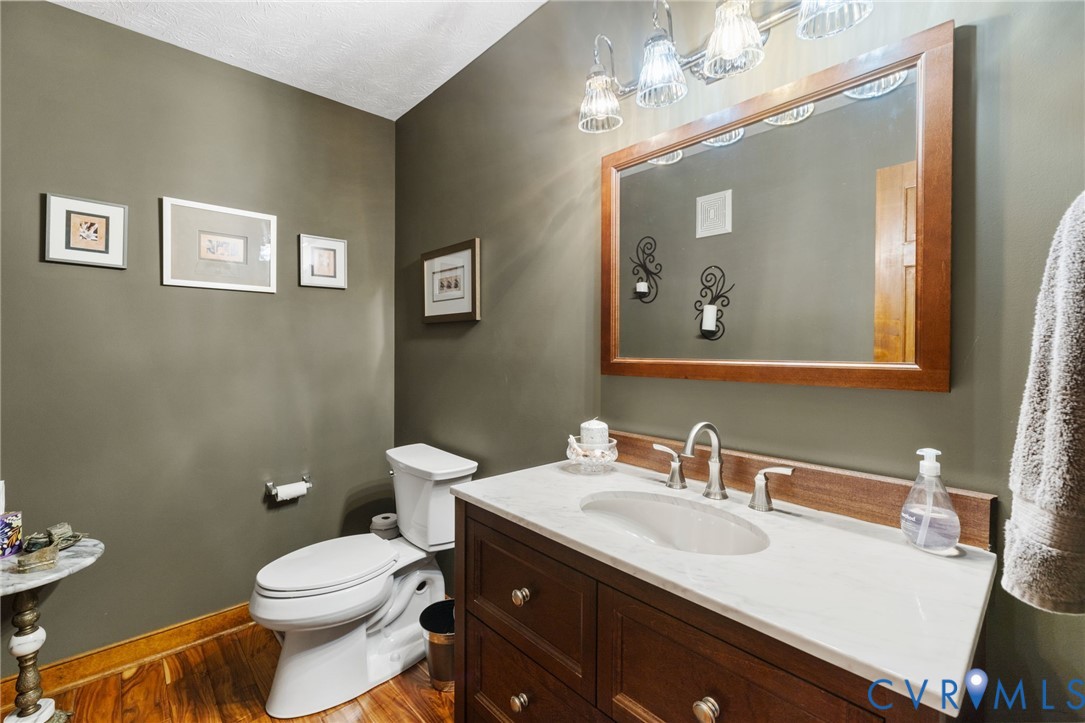 748 Factory Mill Road Bumpass, VA 23024 - Photo 14 of 44 a bathroom with a toilet a sink and mirror