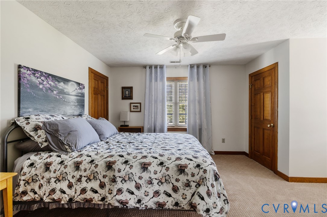 748 Factory Mill Road Bumpass, VA 23024 - Photo 20 of 44 a bedroom with a large bed and a chandelier