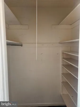 a view of walk in closet with empty racks