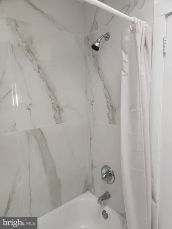 a bathroom with a shower and a bath tub