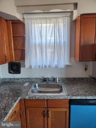 a kitchen with granite countertop a sink a stove and a microwave