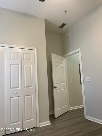 an empty room with wooden floor and closet area