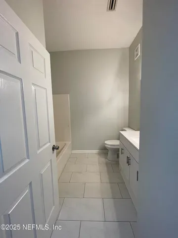 a bathroom with a granite countertop toilet and a sink