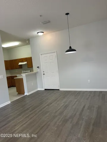 a view of a kitchen with a sink wooden floor and a refrigerator