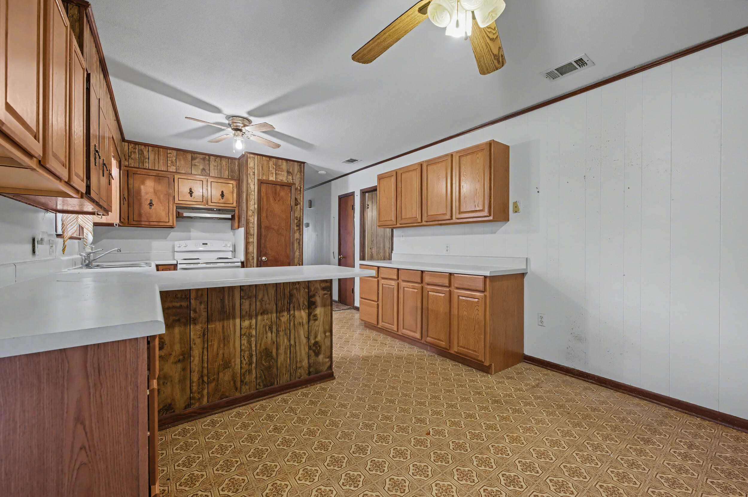 1208 Sunshine Drive Crestview, FL 32539 - Photo 11 of 38 a kitchen with stainless steel appliances granite countertop a sink a stove top oven a chimney cabinets and a counter top space