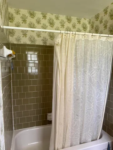 a view of an empty room and chandelier fan