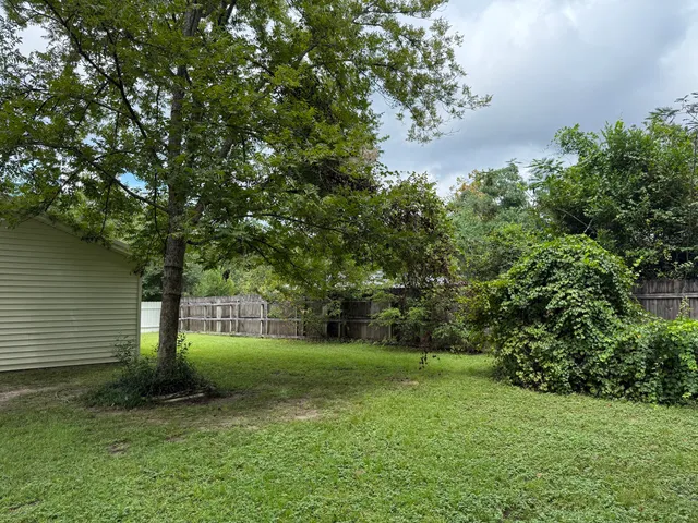 a view of a backyard with a garden and entertaining space