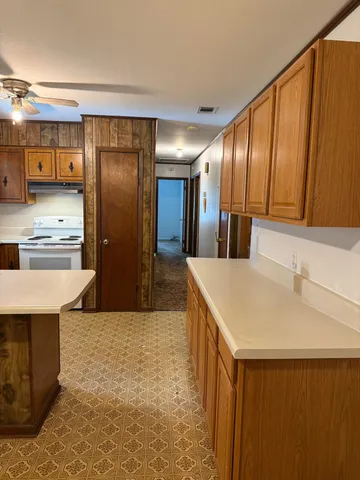a kitchen with kitchen island a sink refrigerator and cabinets
