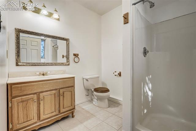 23555 Murphy Road Calhan, CO 80808 - Photo 32 of 49 Bathroom featuring a shower, tile patterned flooring, vanity, and toilet