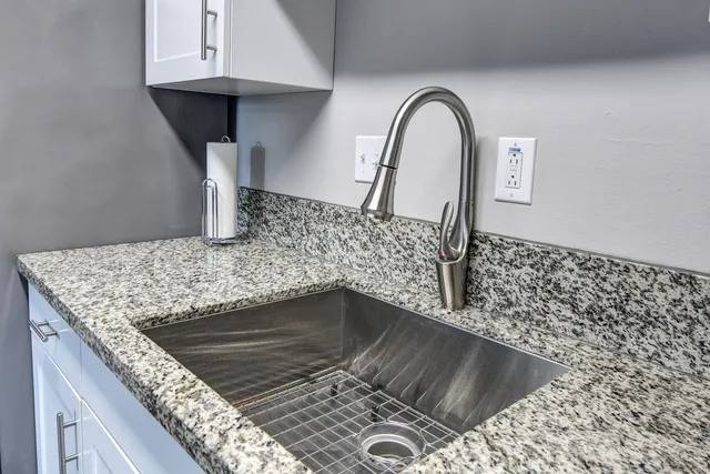 a close view of a sink a faucet and appliance in the kitchen