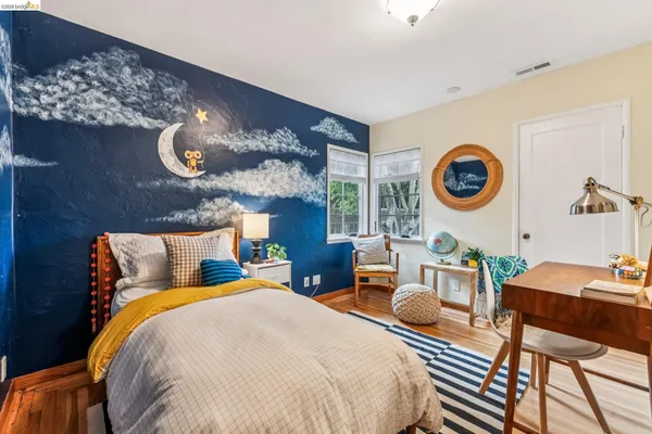 a bedroom with bed and wooden floor