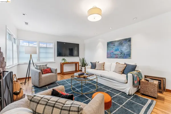 a living room with furniture kitchen view and a flat screen tv